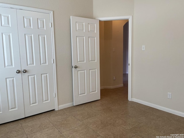 unfurnished bedroom with baseboards and light tile patterned floors