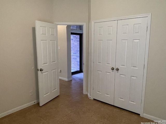 unfurnished bedroom with baseboards and a closet