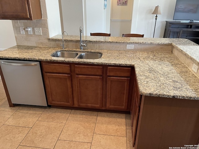 kitchen featuring light tile patterned floors, a sink, light stone countertops, dishwasher, and tasteful backsplash