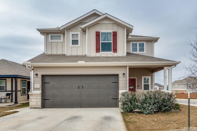 view of front of house featuring board and batten siding, driveway, a shingled roof, and an attached garage