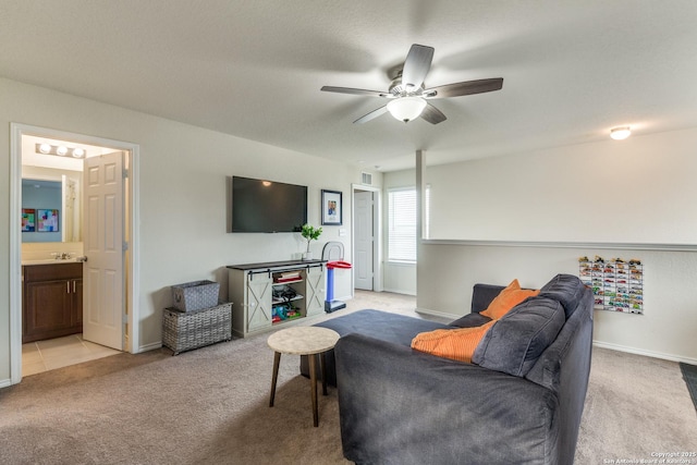 living area featuring light carpet, ceiling fan, and baseboards