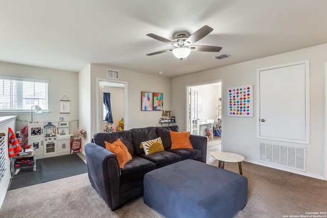 carpeted living area with a ceiling fan, visible vents, and baseboards