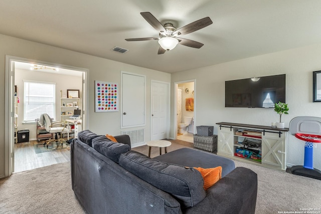 carpeted living area with ceiling fan and visible vents