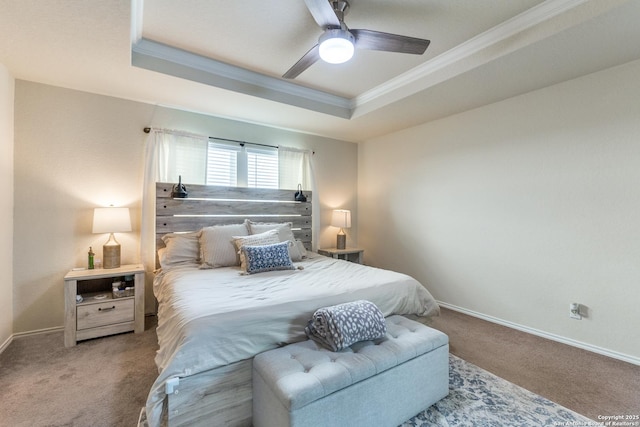 carpeted bedroom featuring baseboards, ceiling fan, a raised ceiling, and crown molding