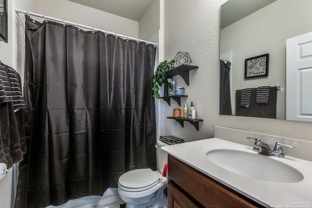 bathroom with a shower with shower curtain, a textured wall, vanity, and toilet