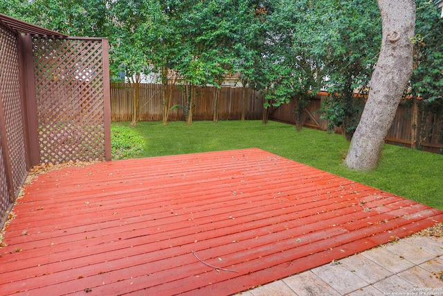 wooden terrace with a fenced backyard and a yard