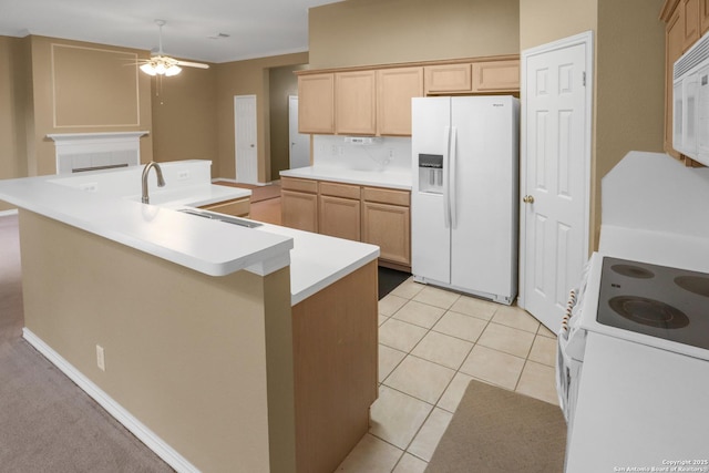 kitchen featuring white appliances, a center island with sink, light countertops, light brown cabinets, and light tile patterned flooring