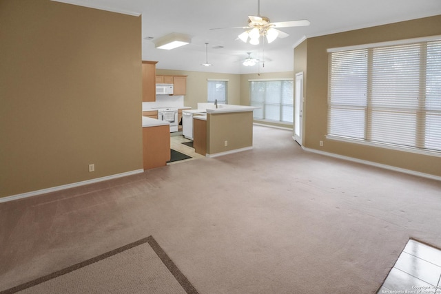 unfurnished living room with light carpet, baseboards, lofted ceiling, ceiling fan, and a sink