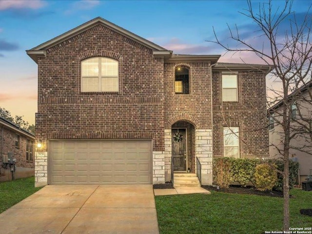 traditional home featuring stone siding, brick siding, driveway, and an attached garage