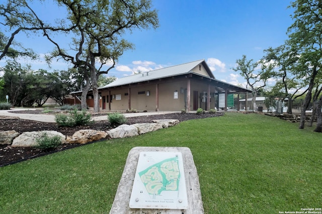 exterior space featuring metal roof and a yard