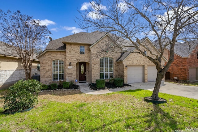 french country inspired facade with brick siding, a shingled roof, concrete driveway, an attached garage, and a front yard