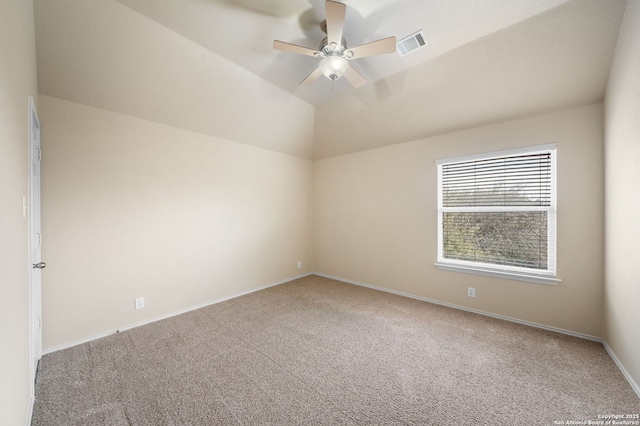 spare room featuring lofted ceiling, ceiling fan, carpet floors, visible vents, and baseboards