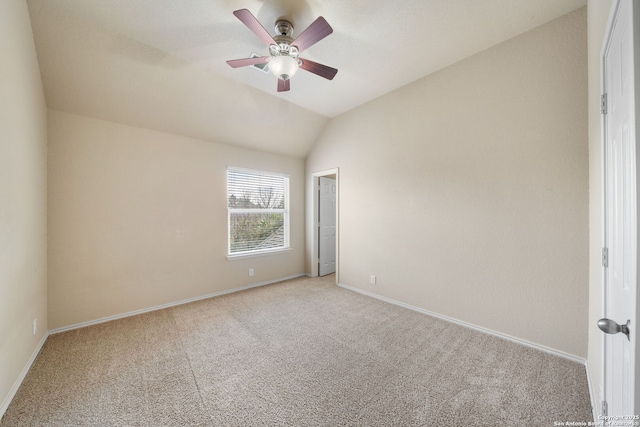 empty room with light colored carpet, vaulted ceiling, baseboards, and ceiling fan