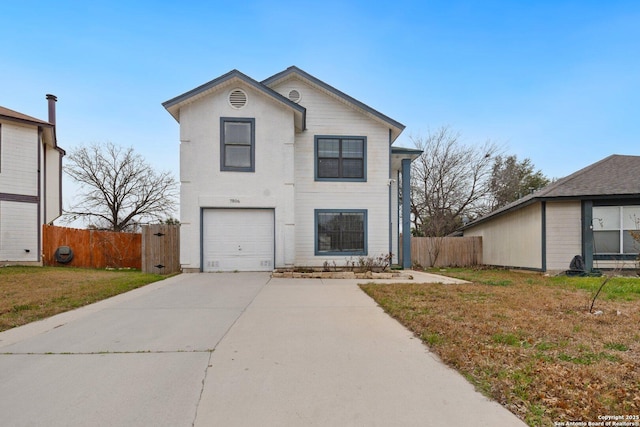 traditional home featuring a garage, fence, a front lawn, and concrete driveway