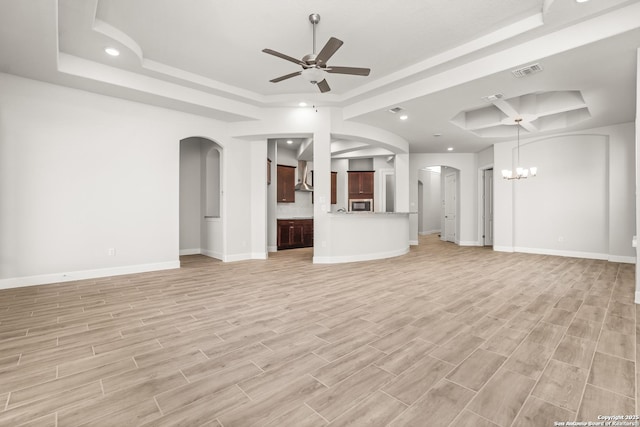 unfurnished living room featuring arched walkways, visible vents, wood finish floors, and ceiling fan with notable chandelier