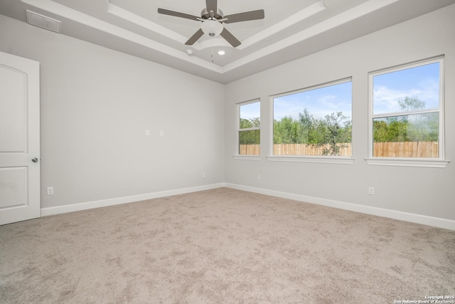 spare room featuring ceiling fan, carpet flooring, visible vents, baseboards, and a raised ceiling