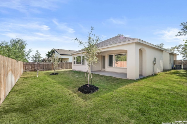 back of house featuring a patio area, a fenced backyard, central AC, and a yard