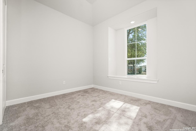 spare room with light carpet and baseboards