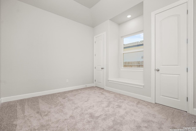 spare room with light carpet and baseboards