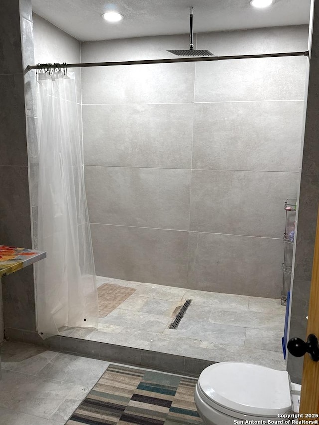 bathroom featuring toilet, a shower stall, and recessed lighting