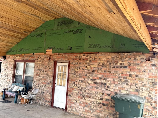 exterior space with a wood stove and brick siding