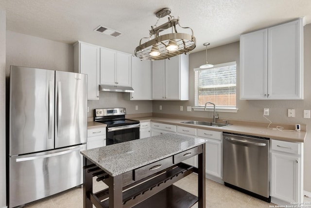 kitchen featuring visible vents, white cabinets, stainless steel appliances, under cabinet range hood, and a sink