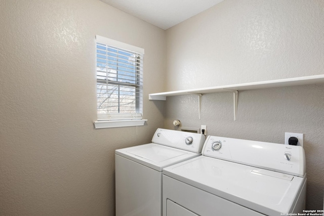 laundry area featuring laundry area, washer and clothes dryer, and a textured wall