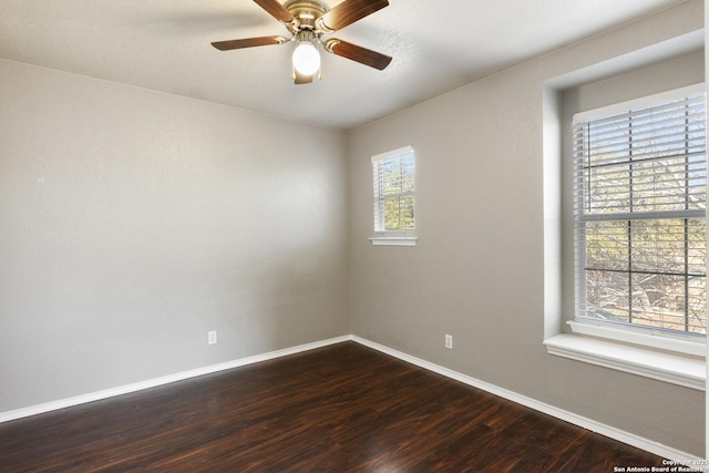 unfurnished room with dark wood-type flooring, ceiling fan, and baseboards