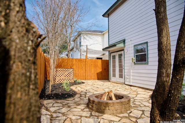 view of patio featuring an outdoor fire pit, a fenced backyard, and french doors