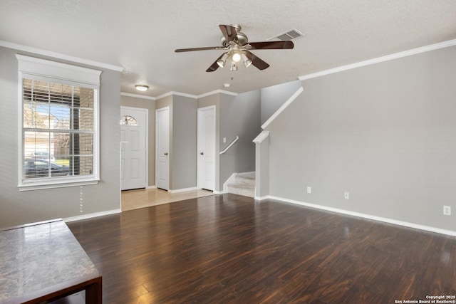 unfurnished living room featuring wood finished floors, visible vents, baseboards, stairs, and ornamental molding