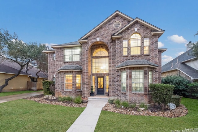 traditional-style house featuring brick siding and a front yard