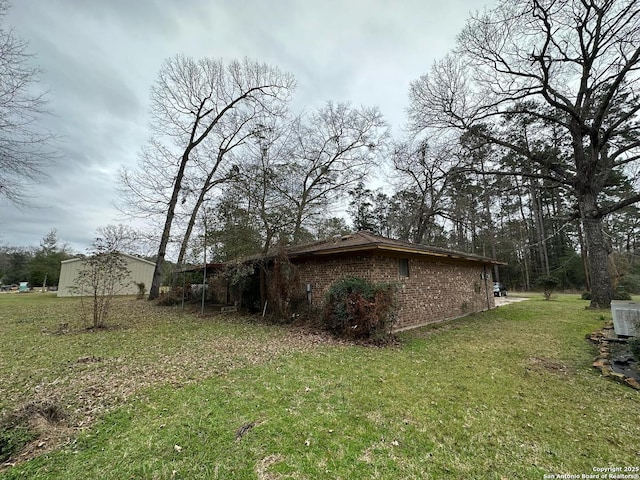 204 Dogwood Ln, Kountze, TX 77625 - view of property exterior featuring brick siding, central AC unit, and a yard