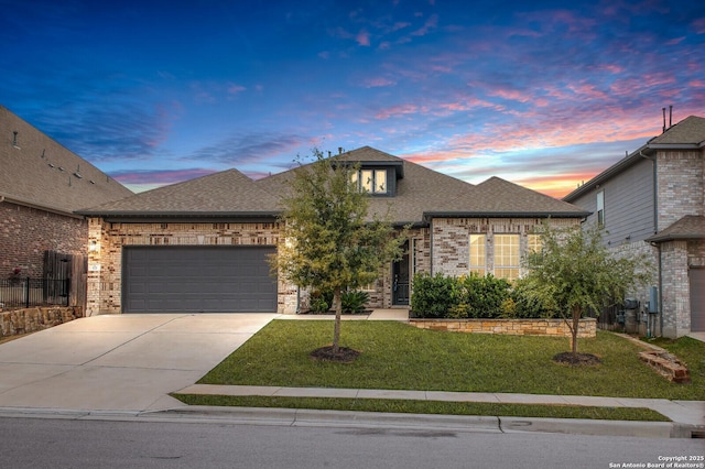 view of front facade featuring a garage, concrete driveway, brick siding, and a front lawn