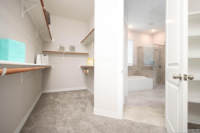 walk in closet featuring light colored carpet