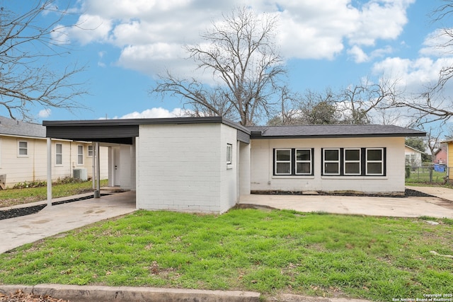 view of front facade featuring cooling unit, concrete block siding, driveway, and a front lawn