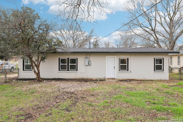 back of property with a yard, brick siding, and fence