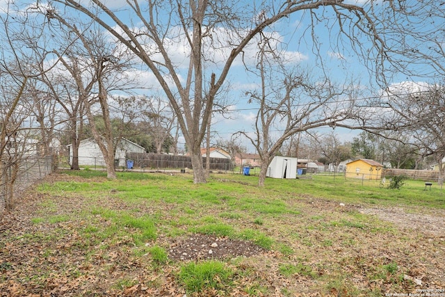 view of yard with a fenced backyard, an outdoor structure, and a shed