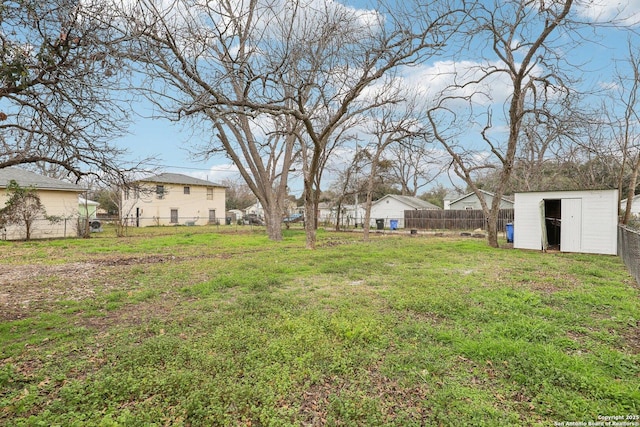 view of yard with an outbuilding, a storage unit, and a fenced backyard