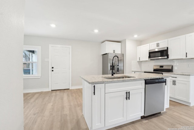 kitchen featuring appliances with stainless steel finishes, white cabinets, and light wood finished floors