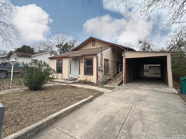 view of front of home with concrete driveway, an attached carport, and stucco siding