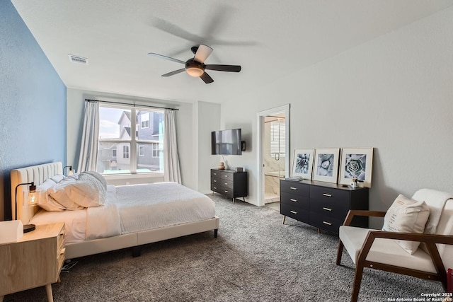 carpeted bedroom featuring ensuite bathroom, a textured wall, visible vents, and a ceiling fan