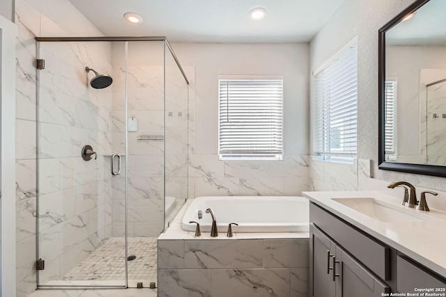 bathroom with a stall shower, recessed lighting, a bath, and vanity