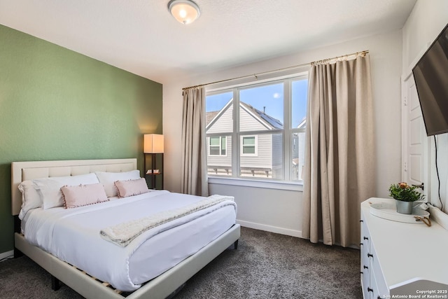 bedroom featuring dark colored carpet and baseboards