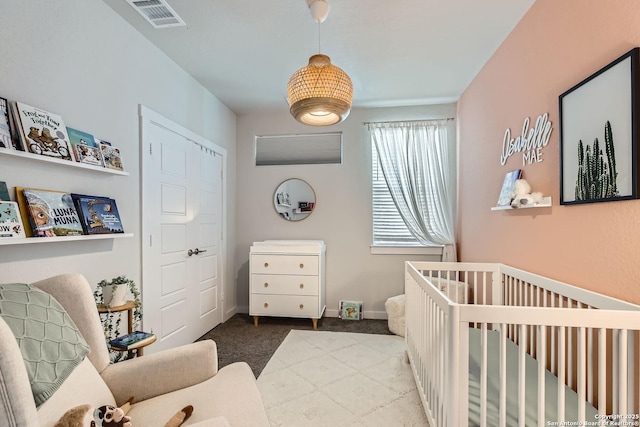 bedroom with a nursery area, visible vents, light carpet, and baseboards