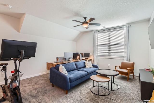 carpeted living area featuring vaulted ceiling, ceiling fan, a textured ceiling, and baseboards