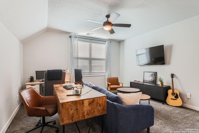 home office featuring a textured ceiling, ceiling fan, carpet floors, visible vents, and vaulted ceiling