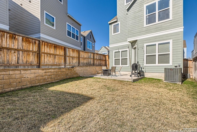 rear view of property with a patio, a yard, a fenced backyard, and central air condition unit