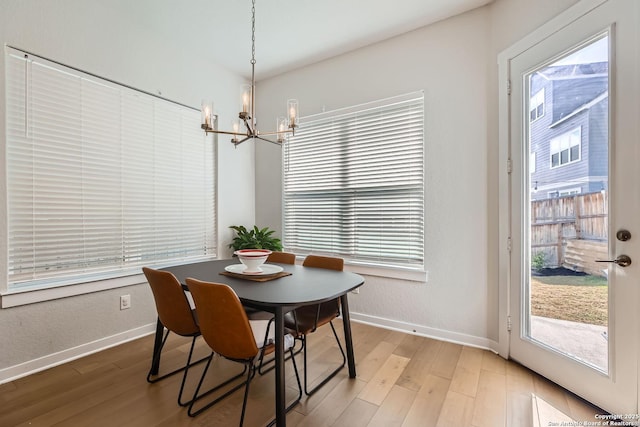 dining room with light wood finished floors, a wealth of natural light, and baseboards