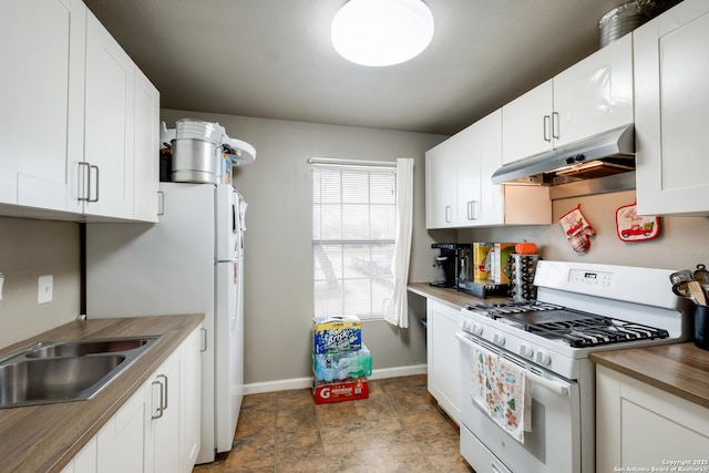 kitchen featuring under cabinet range hood, white range with gas stovetop, baseboards, white cabinets, and wooden counters