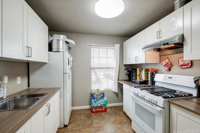 kitchen with under cabinet range hood, white appliances, butcher block countertops, a sink, and white cabinetry